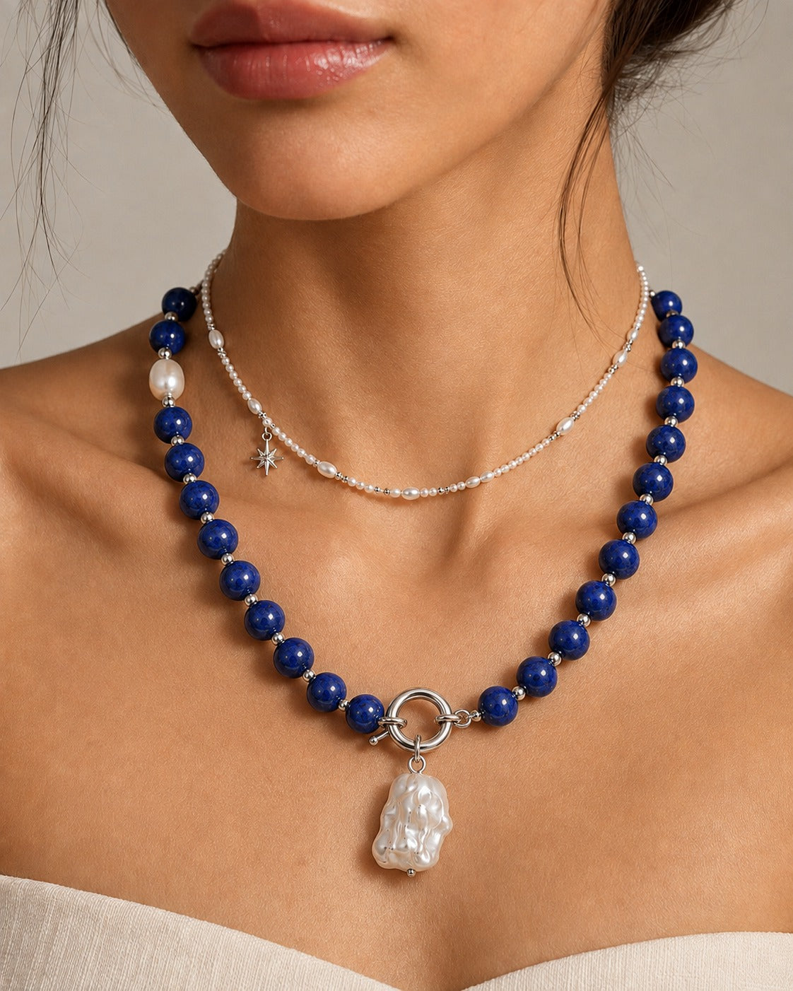 Ensemble Riviera : collier de perles bleu profond porté avec une chaîne fine ton perle